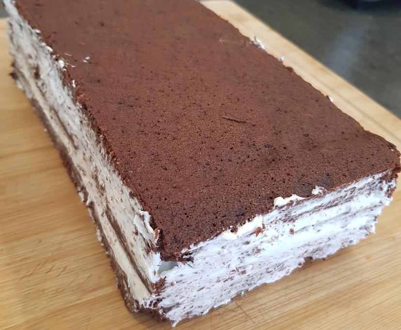 Gâteau au brownie fini avec finitions : recoupe des bordures et crème sur les contours 