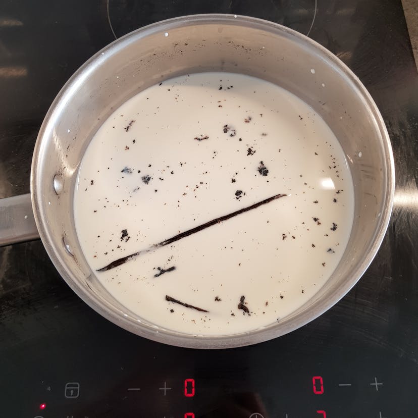 Lait infusé avec la gousse de vanille dans une casserole 