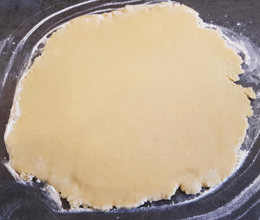 Pâte sucrée étalée finement sur un plan de travail fariné